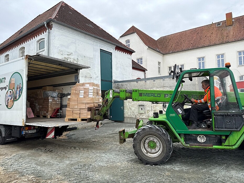 Ein Teleskoplader entläd ein LKW.