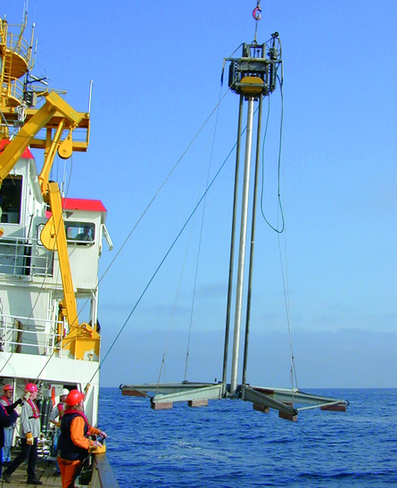 Offshorebohrung Von einem Schiff wird auf hoher See eine Bohreinrichtung zu Wasser gelassen.