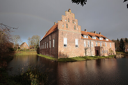 Stimmungsvolles Foto einer Burg mit Wassergraben im Vordergrund